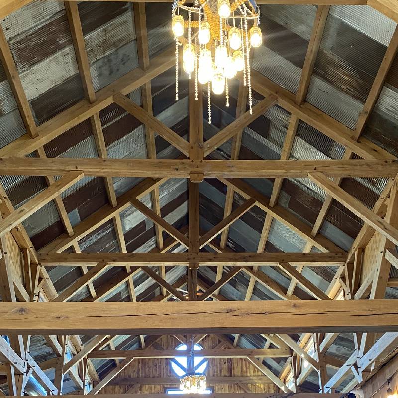 a barn with wooden beams and chandeliers